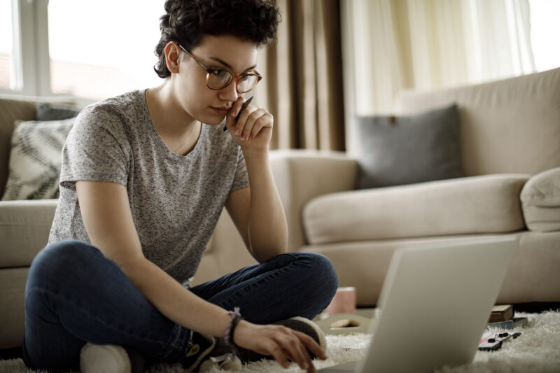 young mixed race woman looking at a laptop