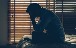 silhouette of a man sitting on bed